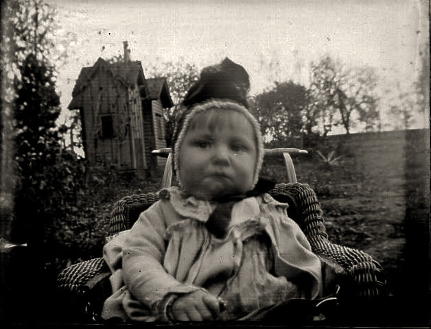 Unknown child and not sure if that's a playhouse behind