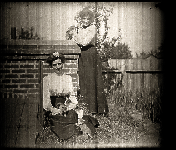 Aunt Ollie and Aunt Jessie by a root cellar with kitties