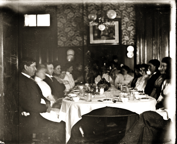 Uncle Horris and Aunt Jessie (third and fourth from left)  Food was set inside doors on back wall from the pantry off the kitchen then served. The table was brought from Kentucky where it was used by the slaves.